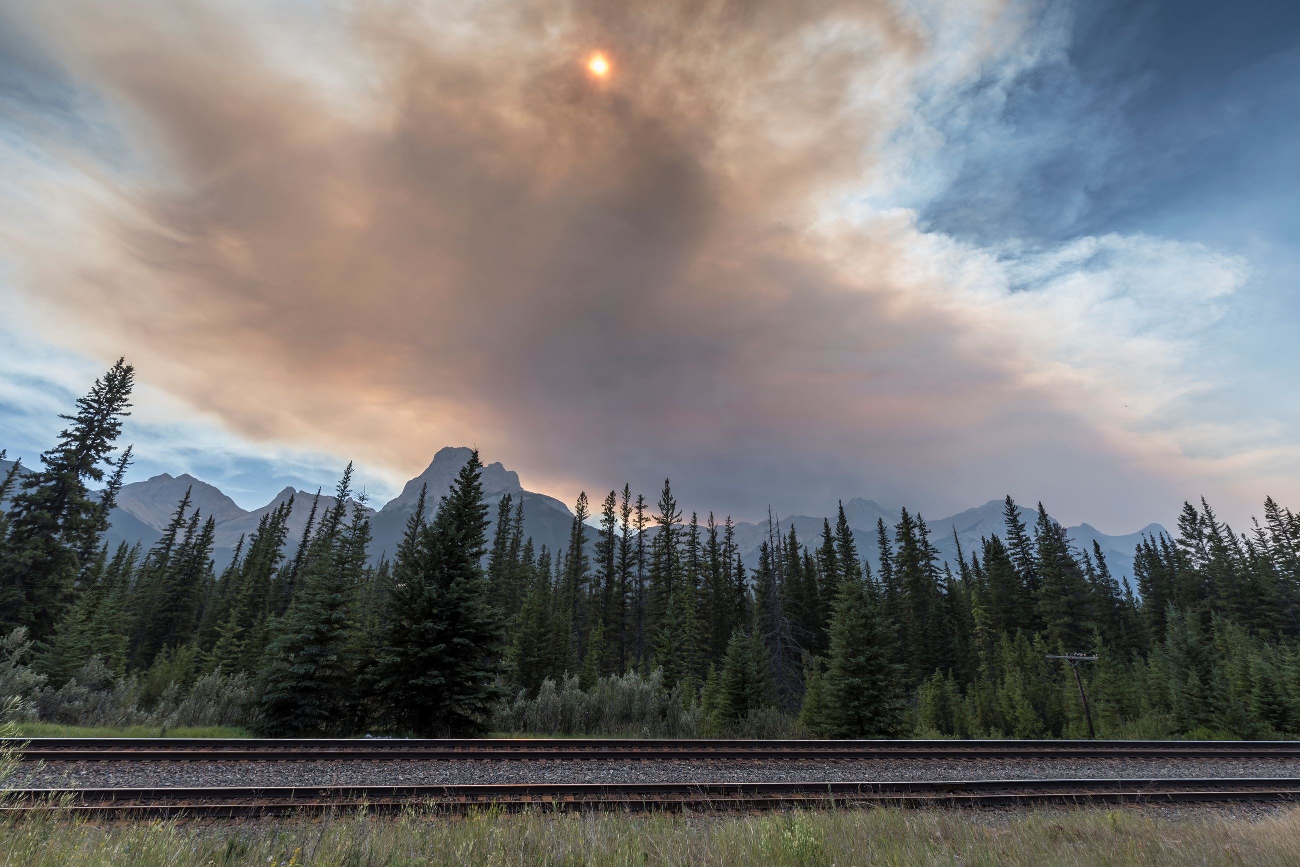 Wildfire smoke over the forest and mountain range